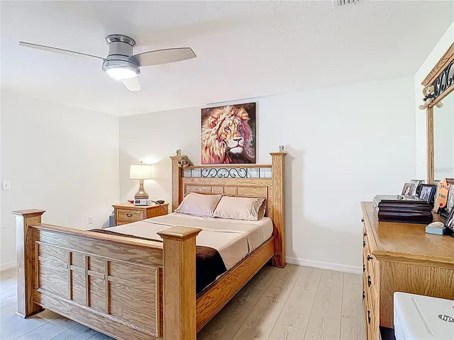 a bedroom with a bed and wooden floor