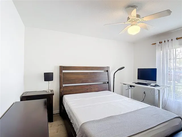 a bedroom with a bed and a flat tv screen on the dresser