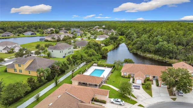 an aerial view of residential houses with outdoor space and river