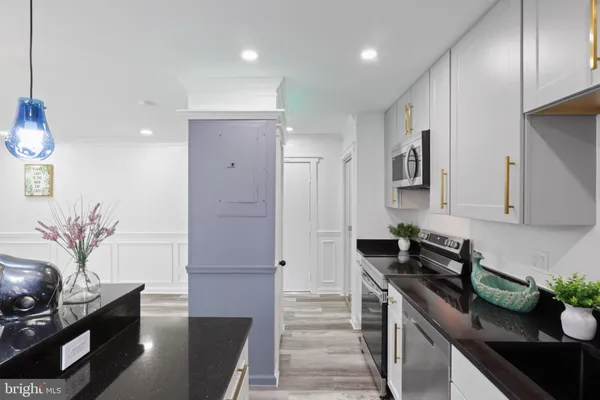 a kitchen with stainless steel appliances granite countertop a refrigerator a sink and a stove