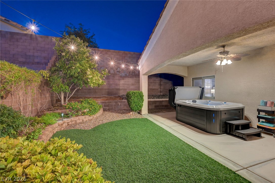 1604 Cattle Ranch Place Henderson, NV 89002 - Photo 87 of 99 Unwind in the private spa within a beautifully landscaped backyard featuring string lights and lush greenery.