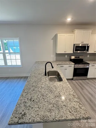 a kitchen with stainless steel appliances granite countertop a refrigerator sink and stove