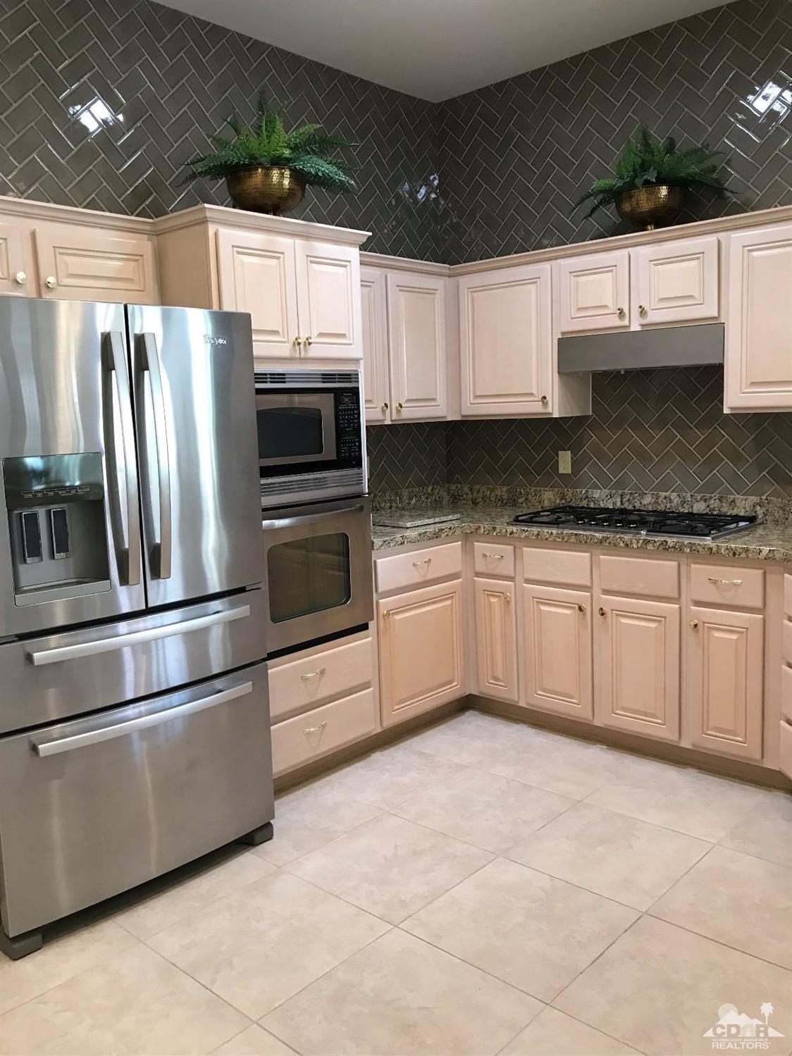 78121 Hunter Point Road Palm Desert, CA 92211 - Photo 5 of 12 a kitchen with granite countertop a white cabinets stainless steel appliances and a counter space