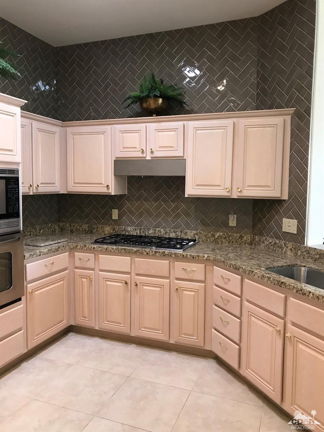 78121 Hunter Point Road Palm Desert, CA 92211 - Photo 8 of 12 a kitchen with granite countertop a sink and white cabinets
