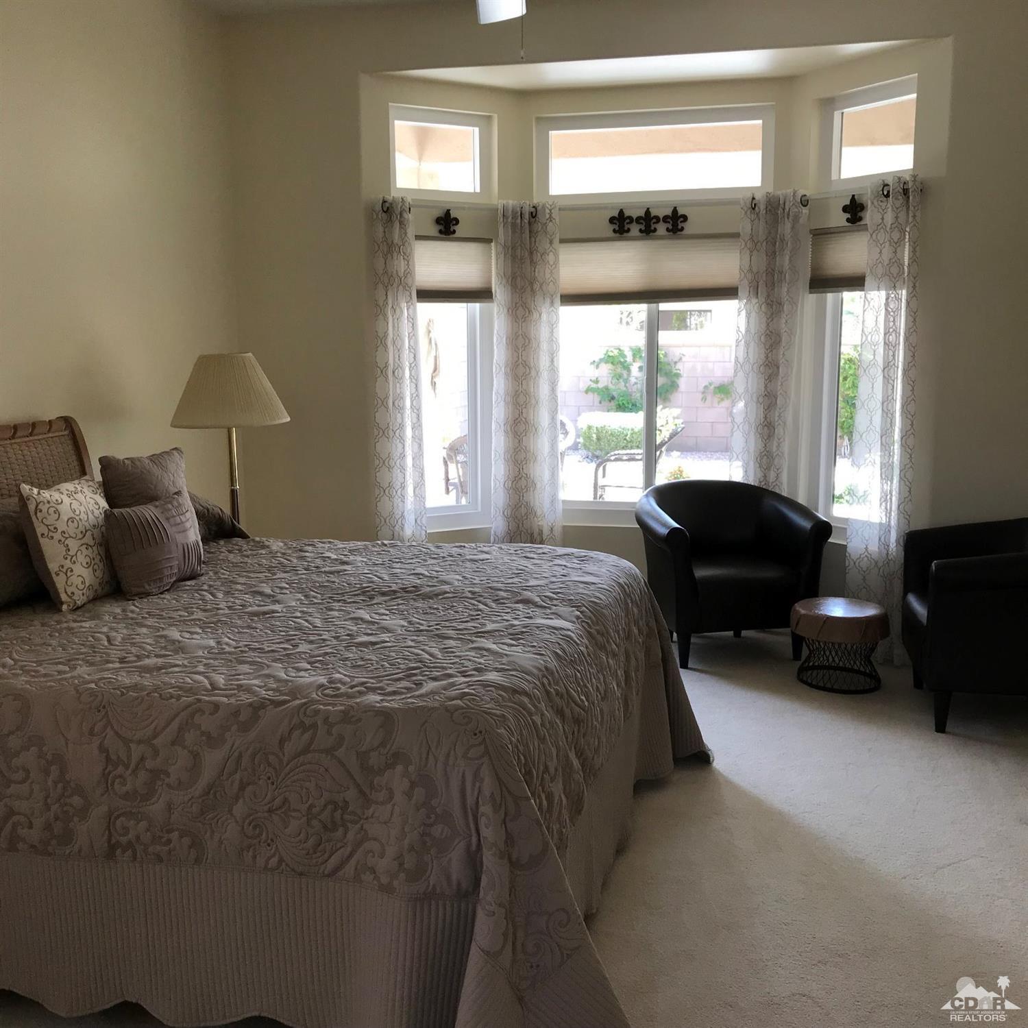 78121 Hunter Point Road Palm Desert, CA 92211 - Photo 9 of 12 a spacious bedroom with a bed and glass window