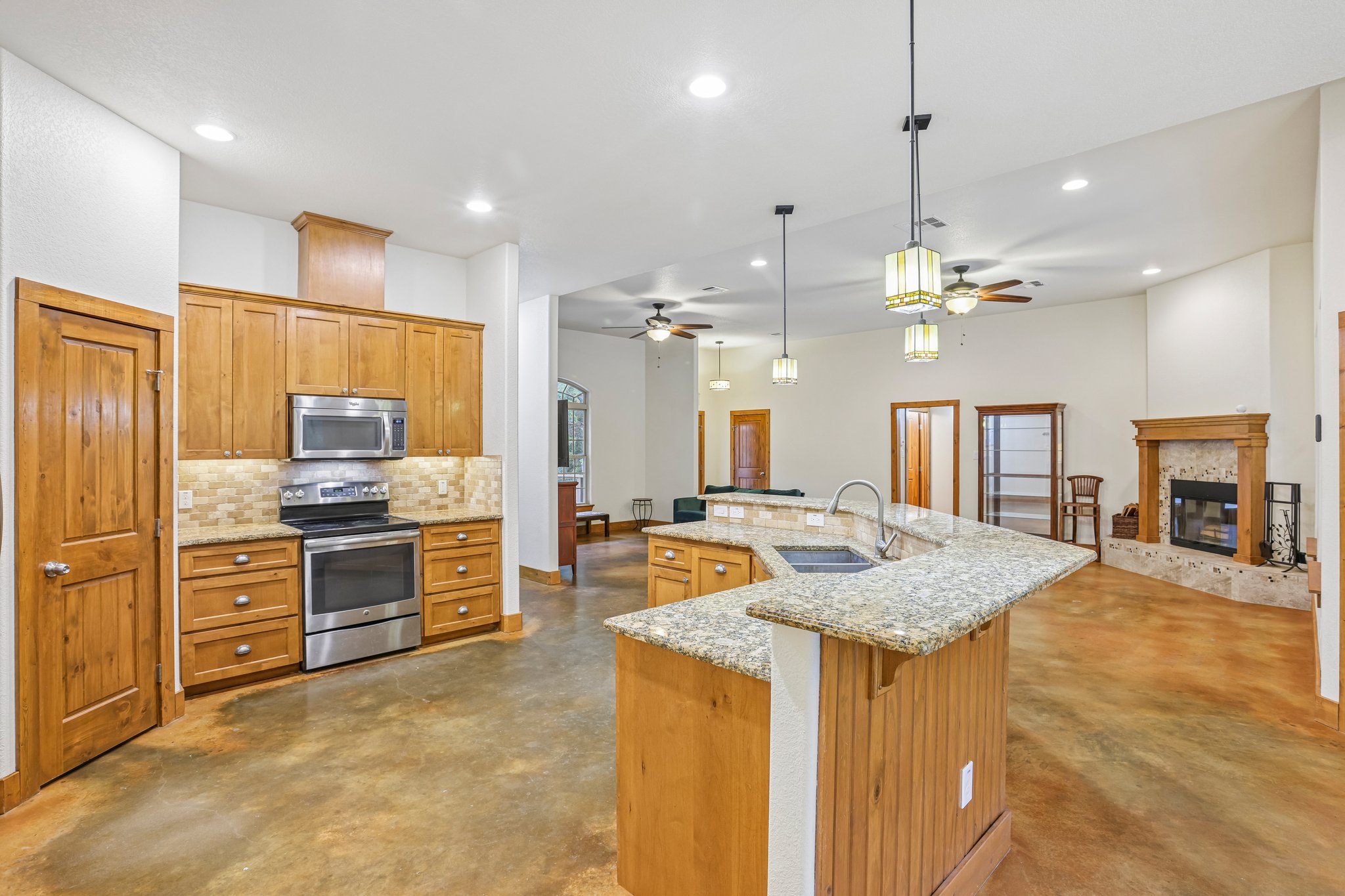 267 Corral Road Smithville, TX 78957 - Photo 18 of 40 Expansive kitchen featuring wood cabinetry, stainless steel appliances, and a tiled backsplash