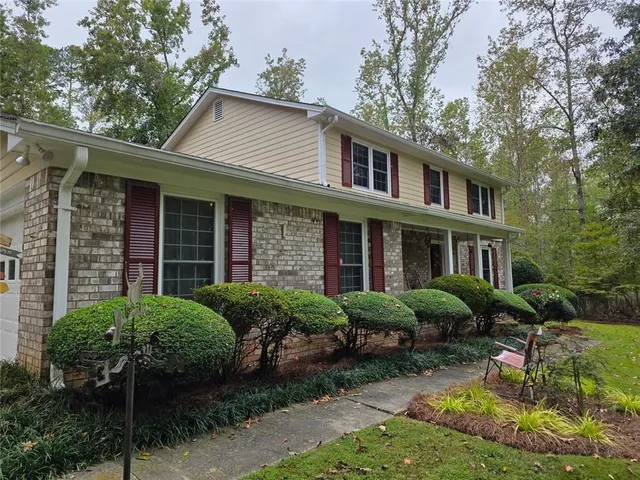 a view of a house with backyard sitting area and garden