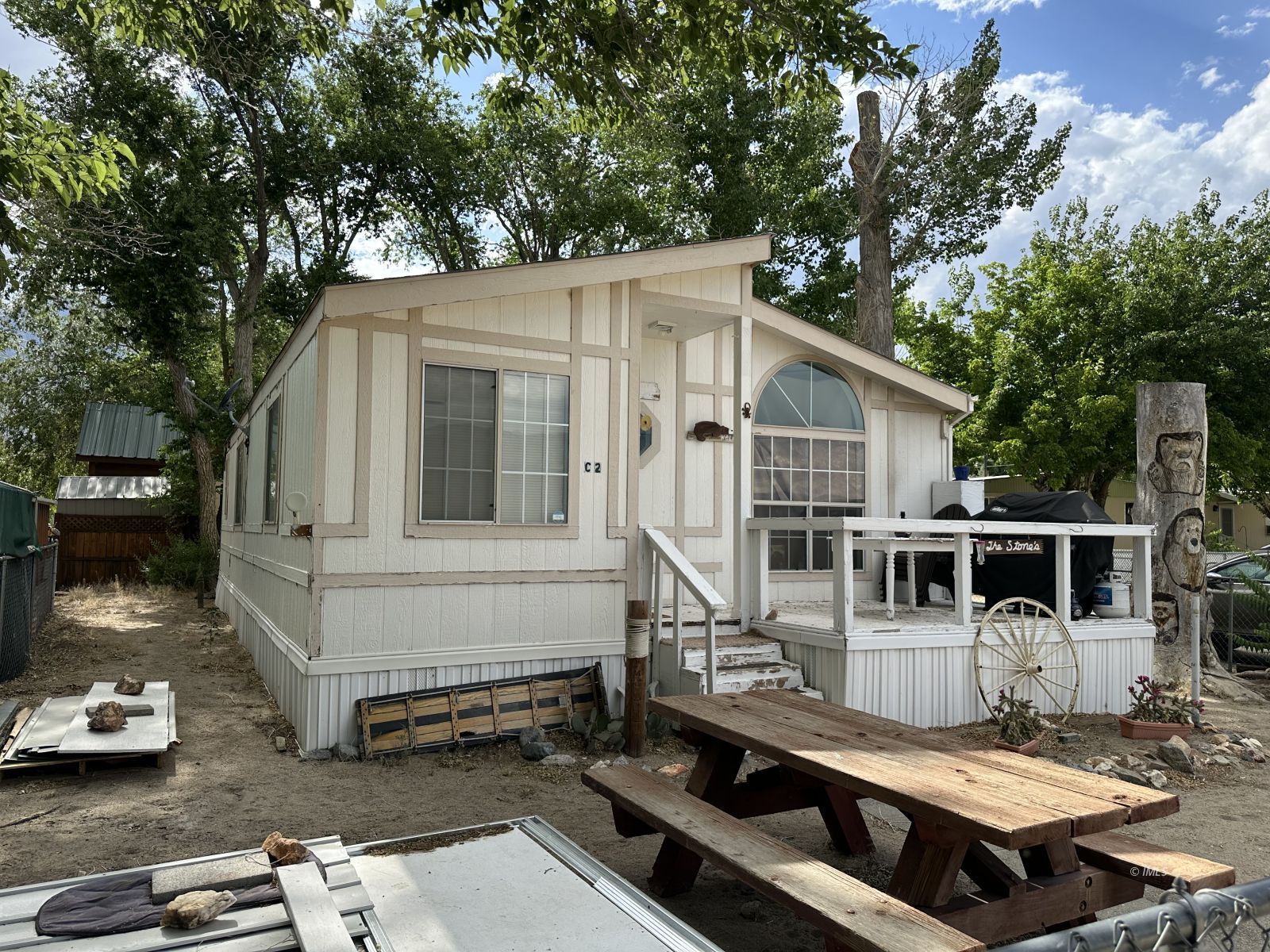 150 Tinnemaha Road, Unit C2 Big Pine, CA 93513 - Photo 19 of 28 a view of a white house with a small yard and large tree