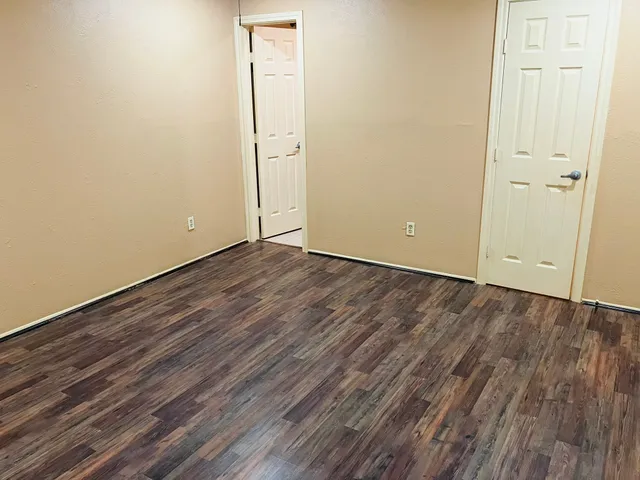 a view of an empty room with closet and wooden floor