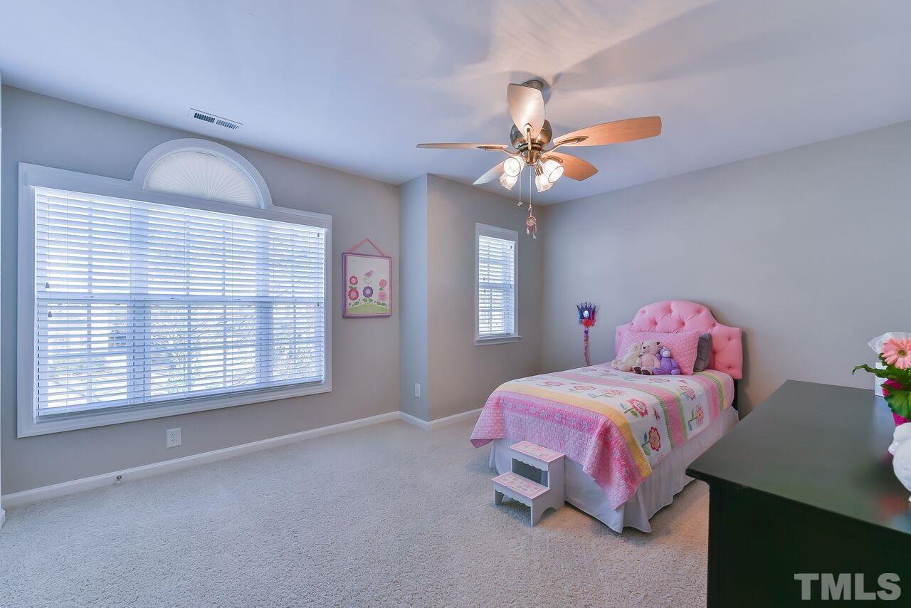 8415 Stone Mason Drive Raleigh, NC 27613 - Photo 8 of 9 a bedroom with a bed and a chandelier