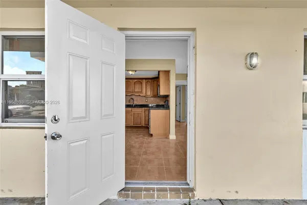 a view of a hallway with wooden floor and a living room