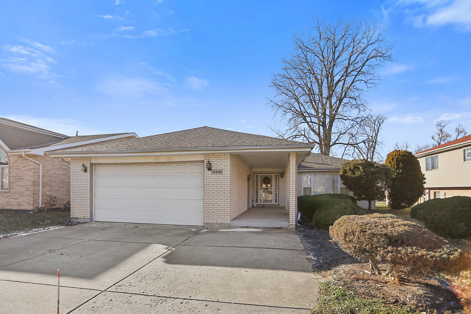 a view of a white house with a large tree