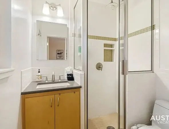 a bathroom with a granite countertop sink mirror and toilet