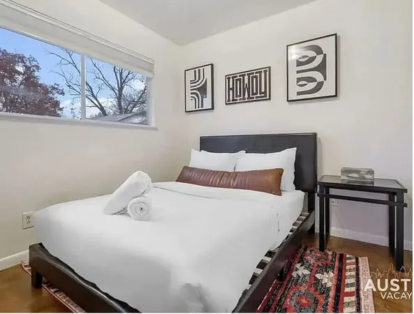 a bedroom with a bed and painting on the wall