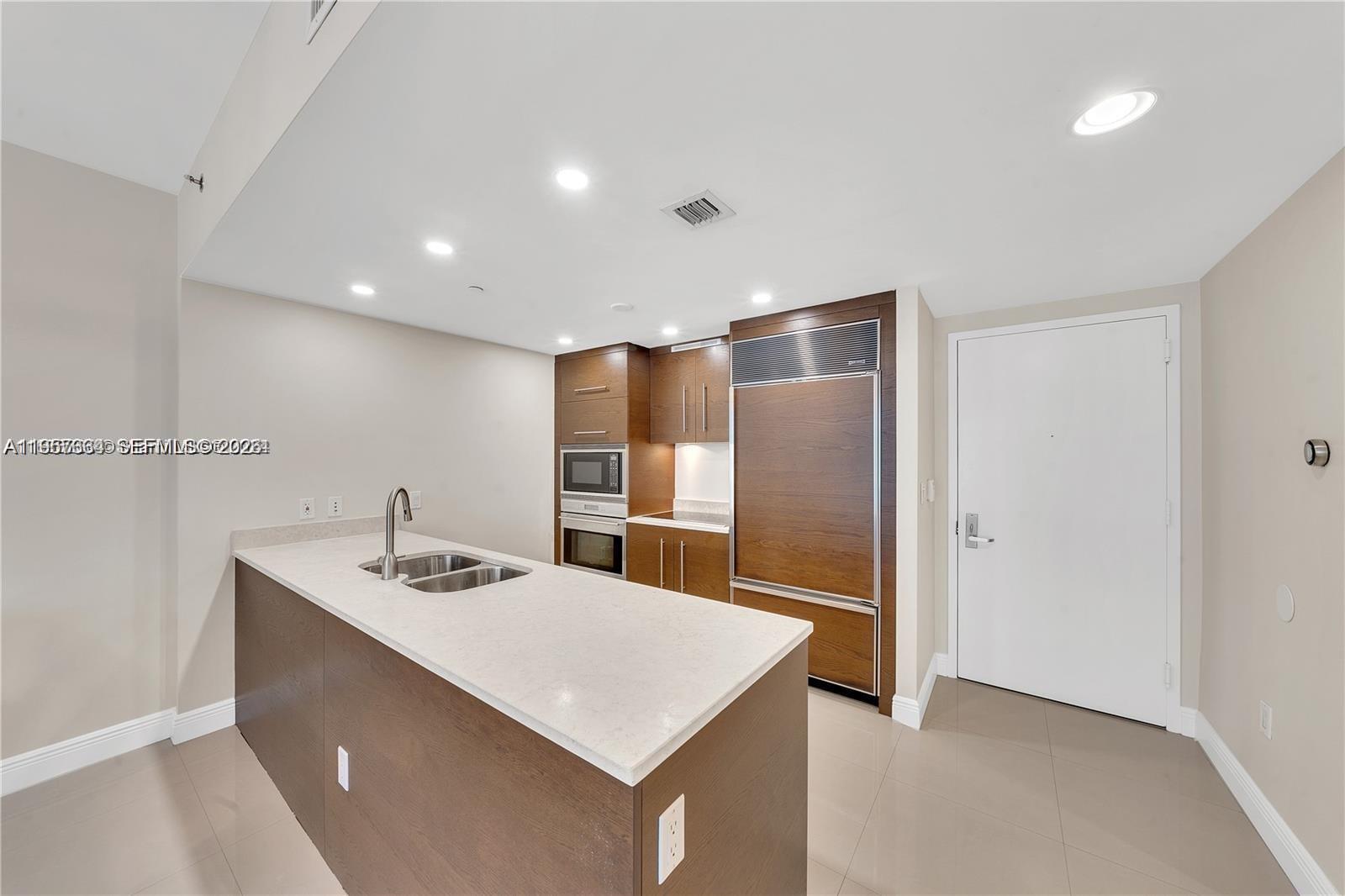 475 Brickell Avenue, Unit 4211 Miami, FL 33131 - Photo 10 of 10 a kitchen with kitchen island a sink appliances and a refrigerator