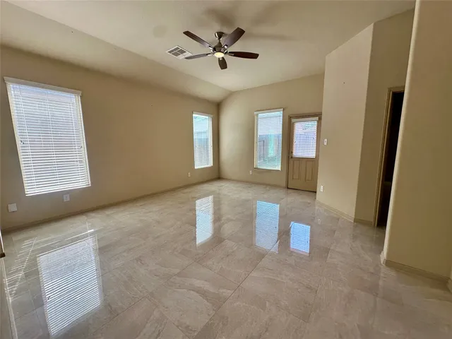 a living room with stainless steel appliances furniture a flat screen tv and a refrigerator