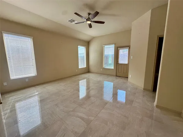 a living room with stainless steel appliances furniture a flat screen tv and a refrigerator