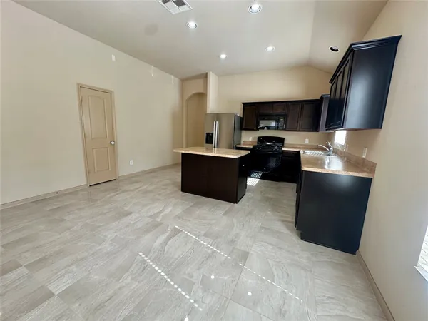 a large kitchen with stainless steel appliances a large counter top