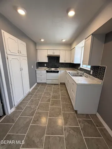 a kitchen with a sink a stove a microwave and cabinets