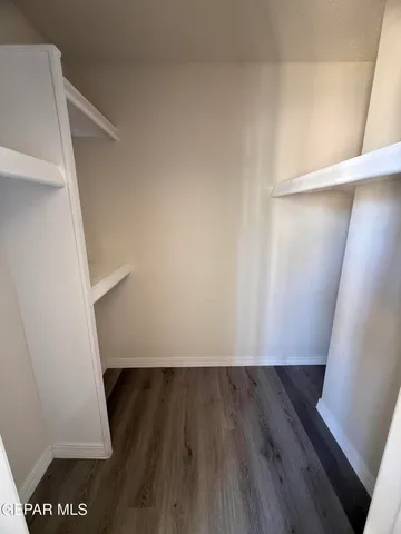 a view of walk in closet with wooden floor