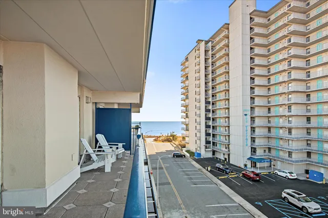 a view of a balcony with chairs and iron stairs