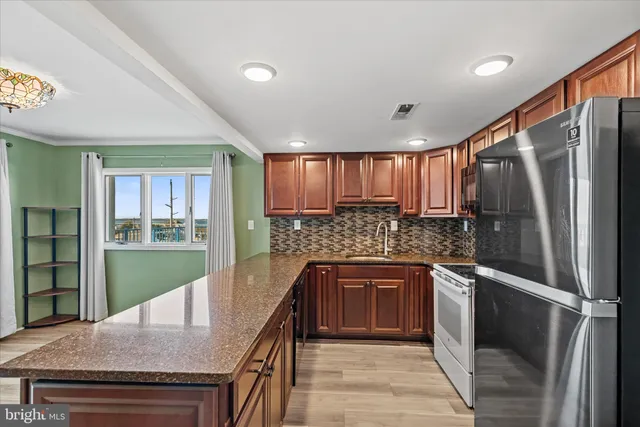 a kitchen with granite countertop a sink stove and cabinets