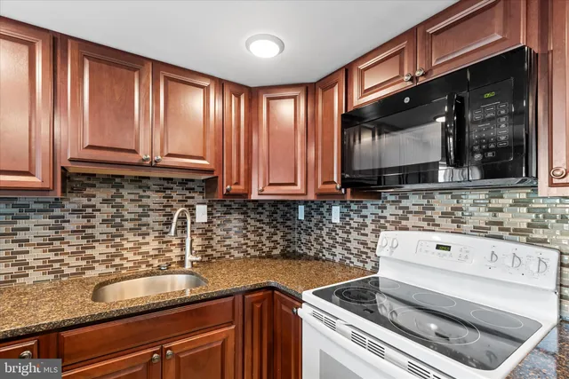 a kitchen with stainless steel appliances granite countertop a refrigerator stove and oven