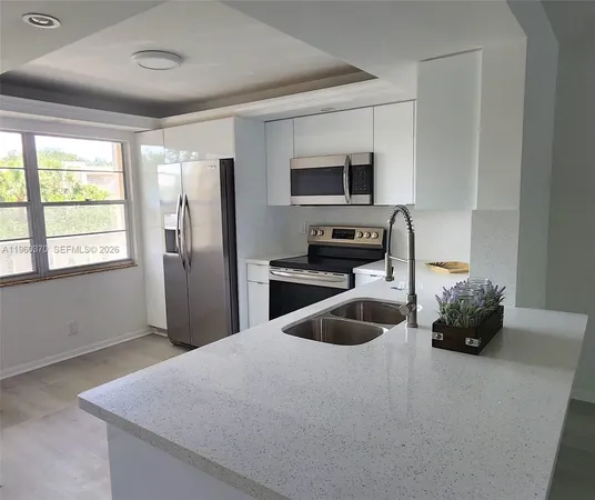 a kitchen with stainless steel appliances a microwave sink and cabinets