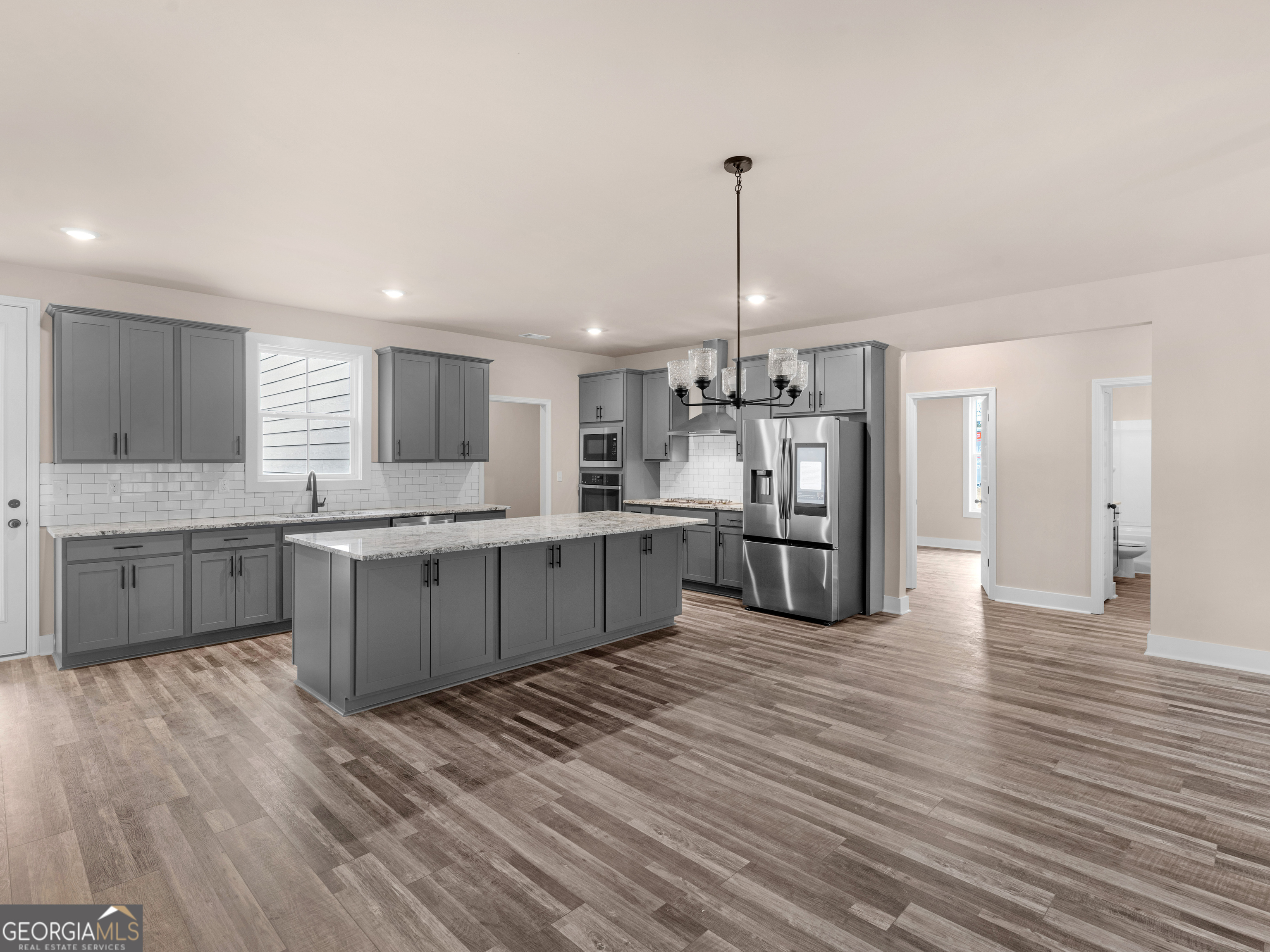 160 Loyd Road Mansfield, GA 30056 - Photo 18 of 53 a large kitchen with stainless steel appliances kitchen island granite countertop a stove a sink dishwasher and a refrigerator with wooden floor