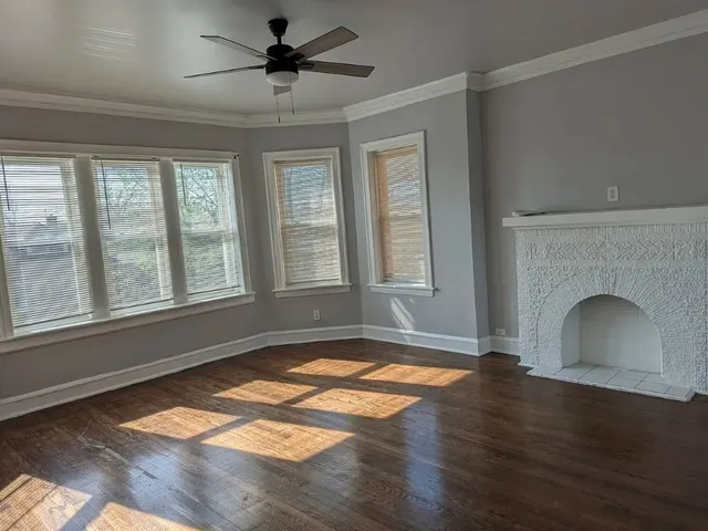a view of an empty room with exposed radiator and fireplace