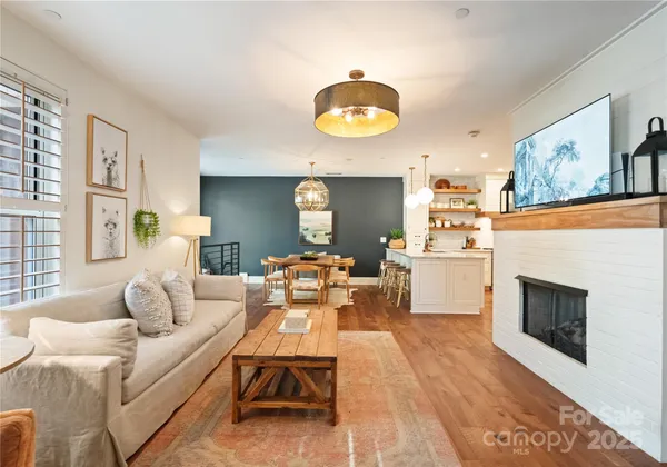 a living room with furniture a fireplace and a large window