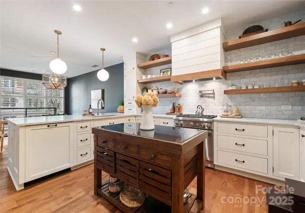a kitchen with stainless steel appliances a stove refrigerator sink and cabinets