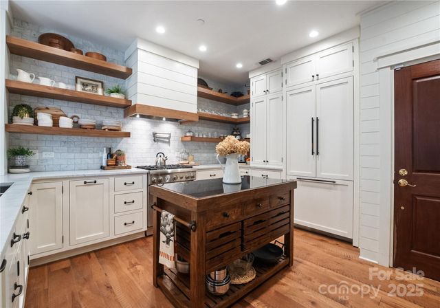 a kitchen with white cabinets and appliances