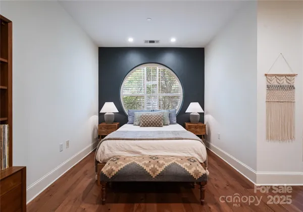 a bedroom with a bed a window and a chandelier