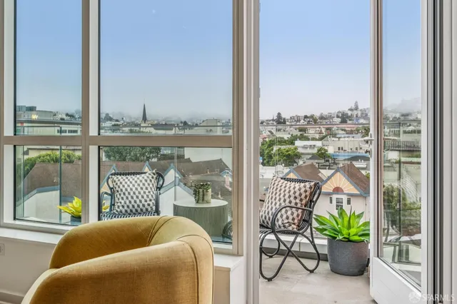 a balcony with furniture and a potted plant