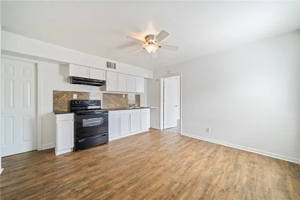 a kitchen with a refrigerator and a stove top oven