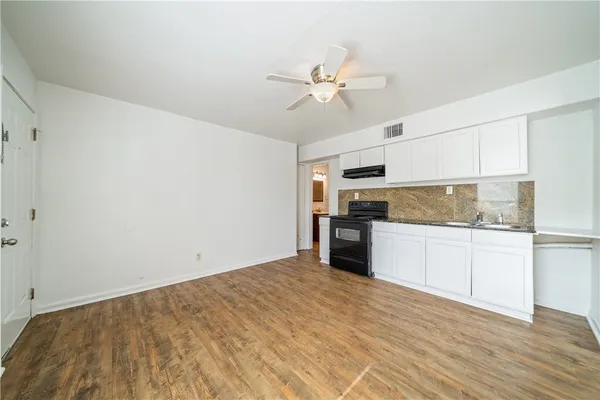 a kitchen with a refrigerator and white cabinets