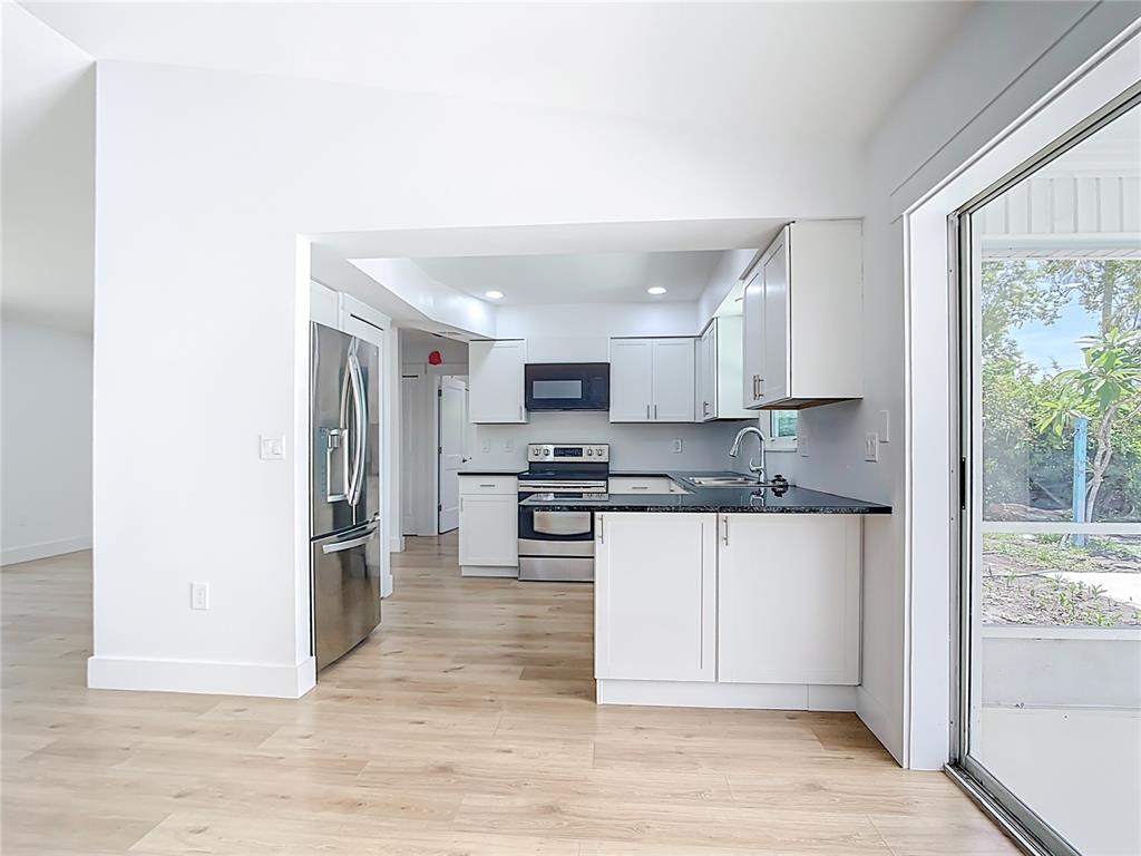 7341 Hart Street Englewood, FL 34224 - Photo 12 of 39 a kitchen with stainless steel appliances granite countertop a refrigerator and a stove top oven