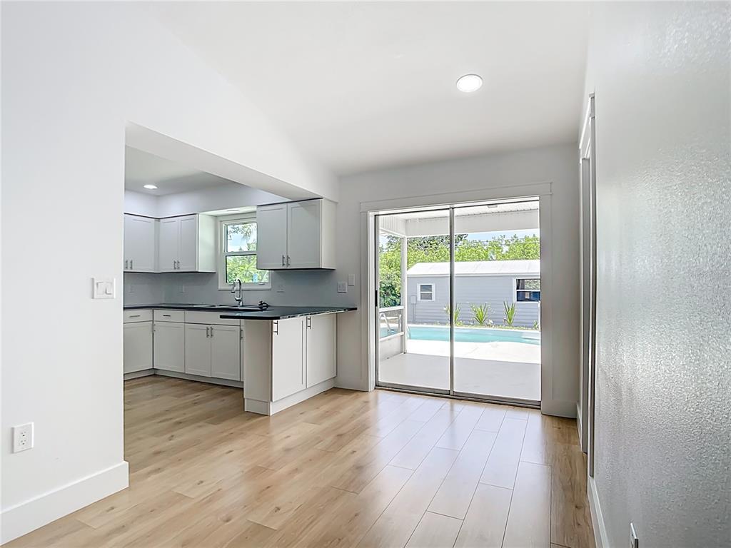 7341 Hart Street Englewood, FL 34224 - Photo 13 of 39 a large kitchen with a wooden floor and a large window