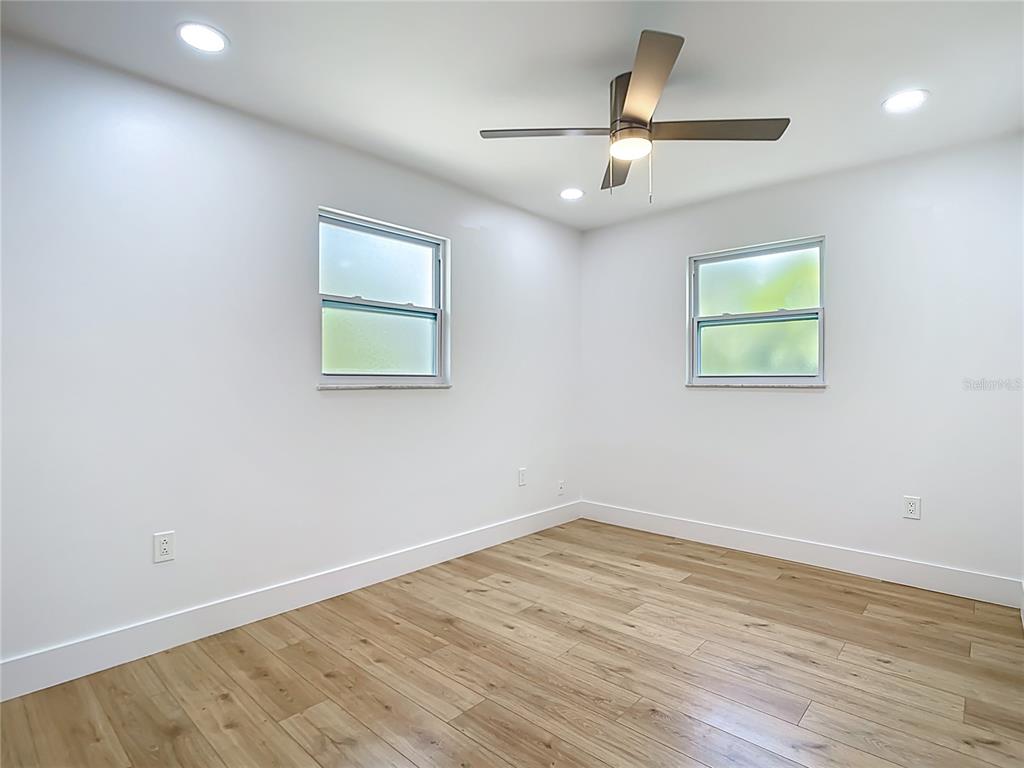 7341 Hart Street Englewood, FL 34224 - Photo 20 of 39 an empty room with wooden floor and ceiling fan