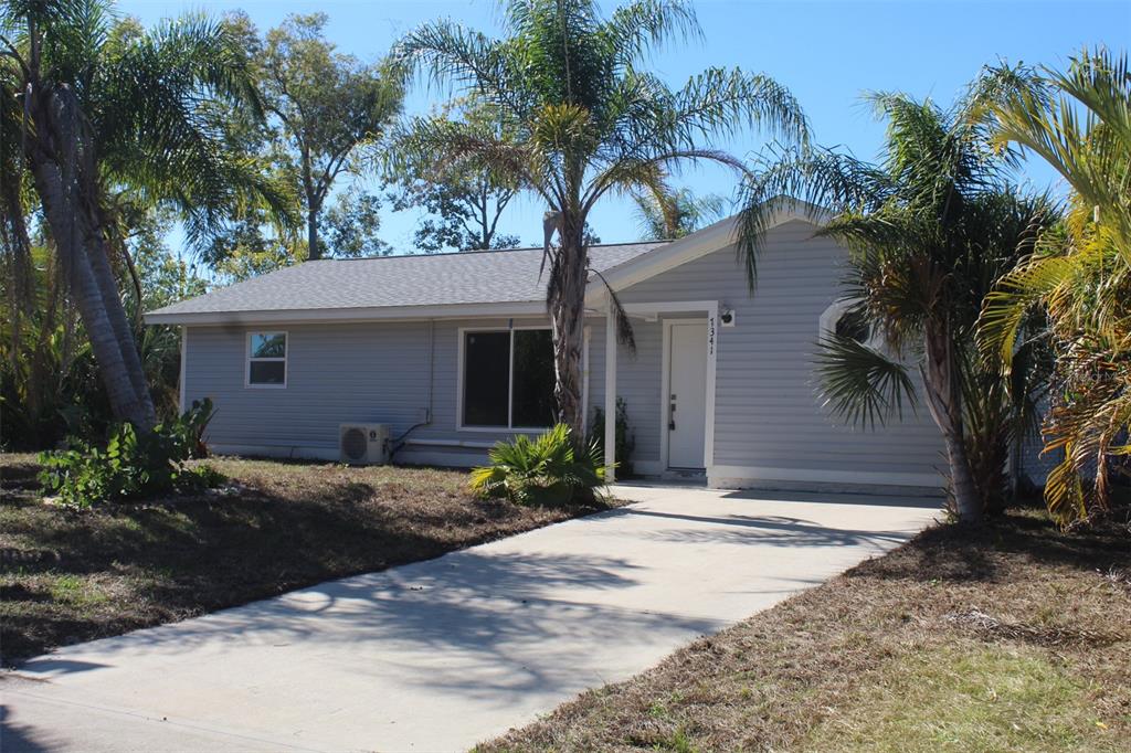 7341 Hart Street Englewood, FL 34224 - Photo 2 of 39 a front view of a house with garden and trees