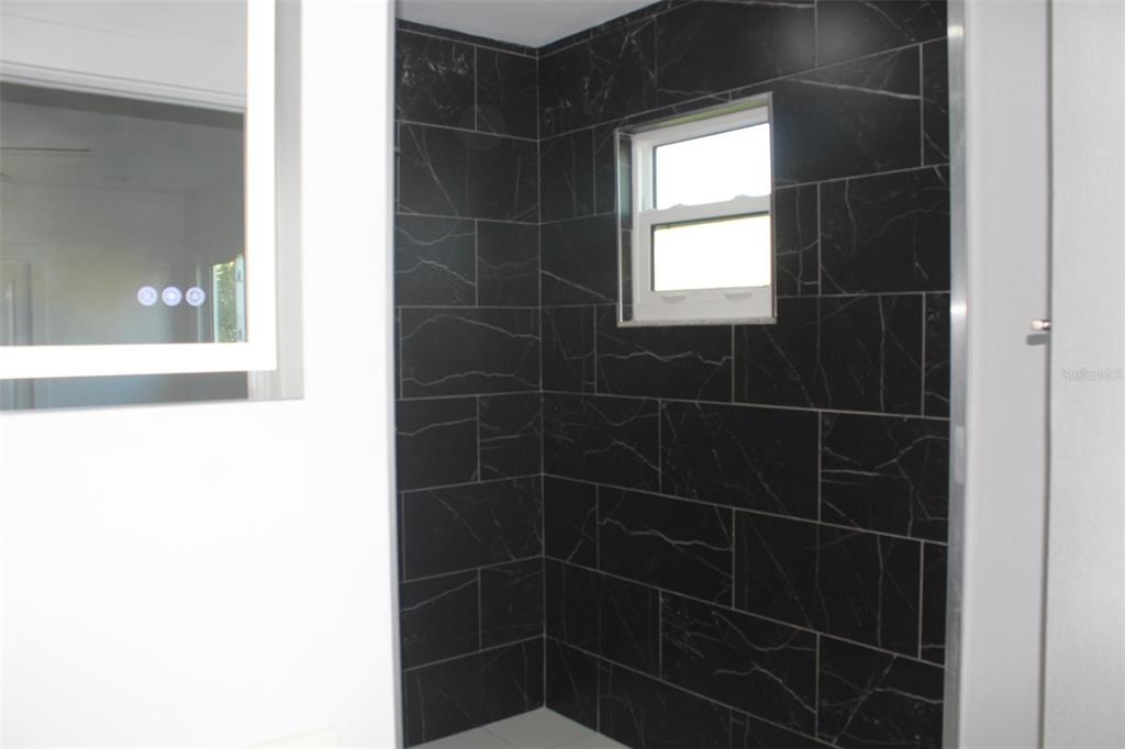 7341 Hart Street Englewood, FL 34224 - Photo 21 of 39 a bathroom with a glass shower door