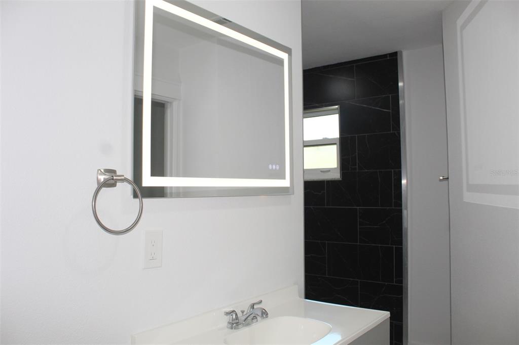 7341 Hart Street Englewood, FL 34224 - Photo 22 of 39 a bathroom with a glass shower door