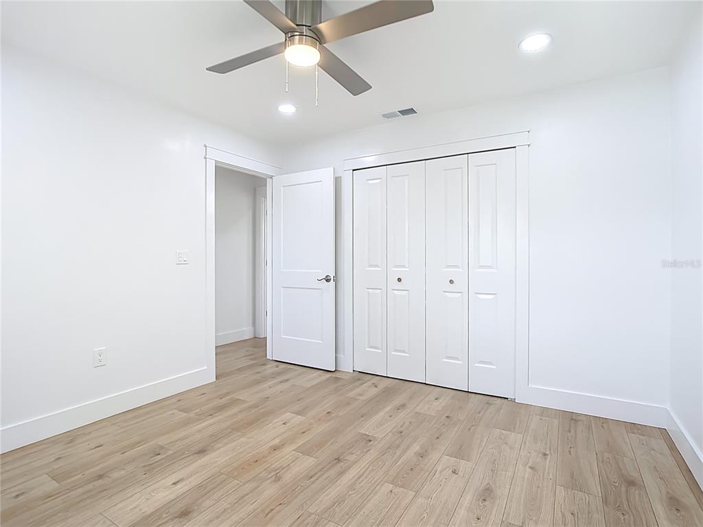 7341 Hart Street Englewood, FL 34224 - Photo 28 of 39 an empty room with wooden floor fan and windows