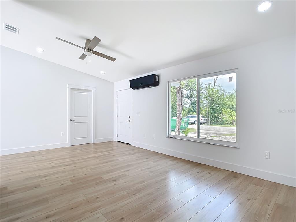7341 Hart Street Englewood, FL 34224 - Photo 5 of 39 an empty room with wooden floor fan and windows