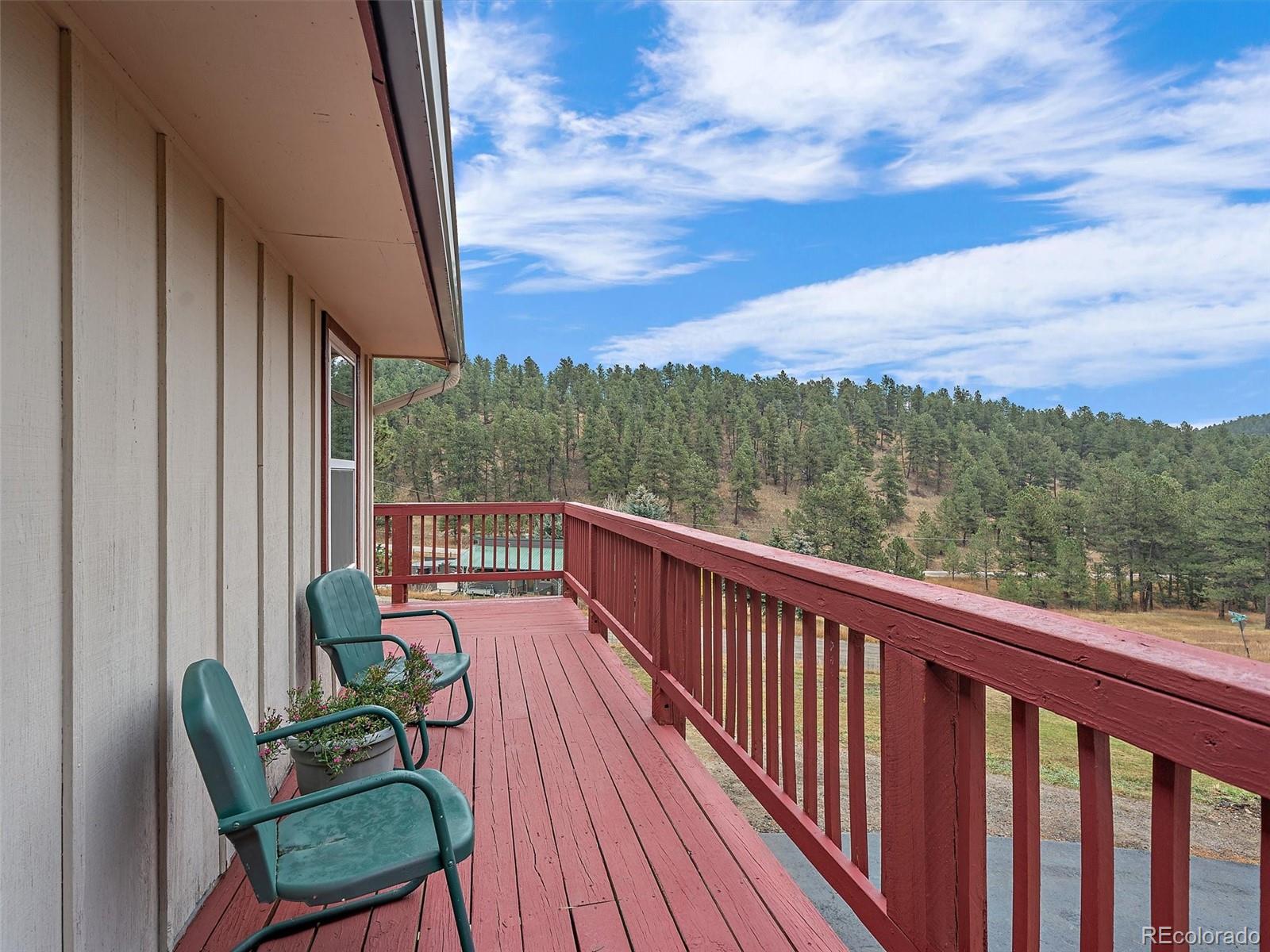27422 Pine Valley Drive Evergreen, CO 80439 - Photo 13 of 42 a view of a balcony with wooden floor and outdoor seating