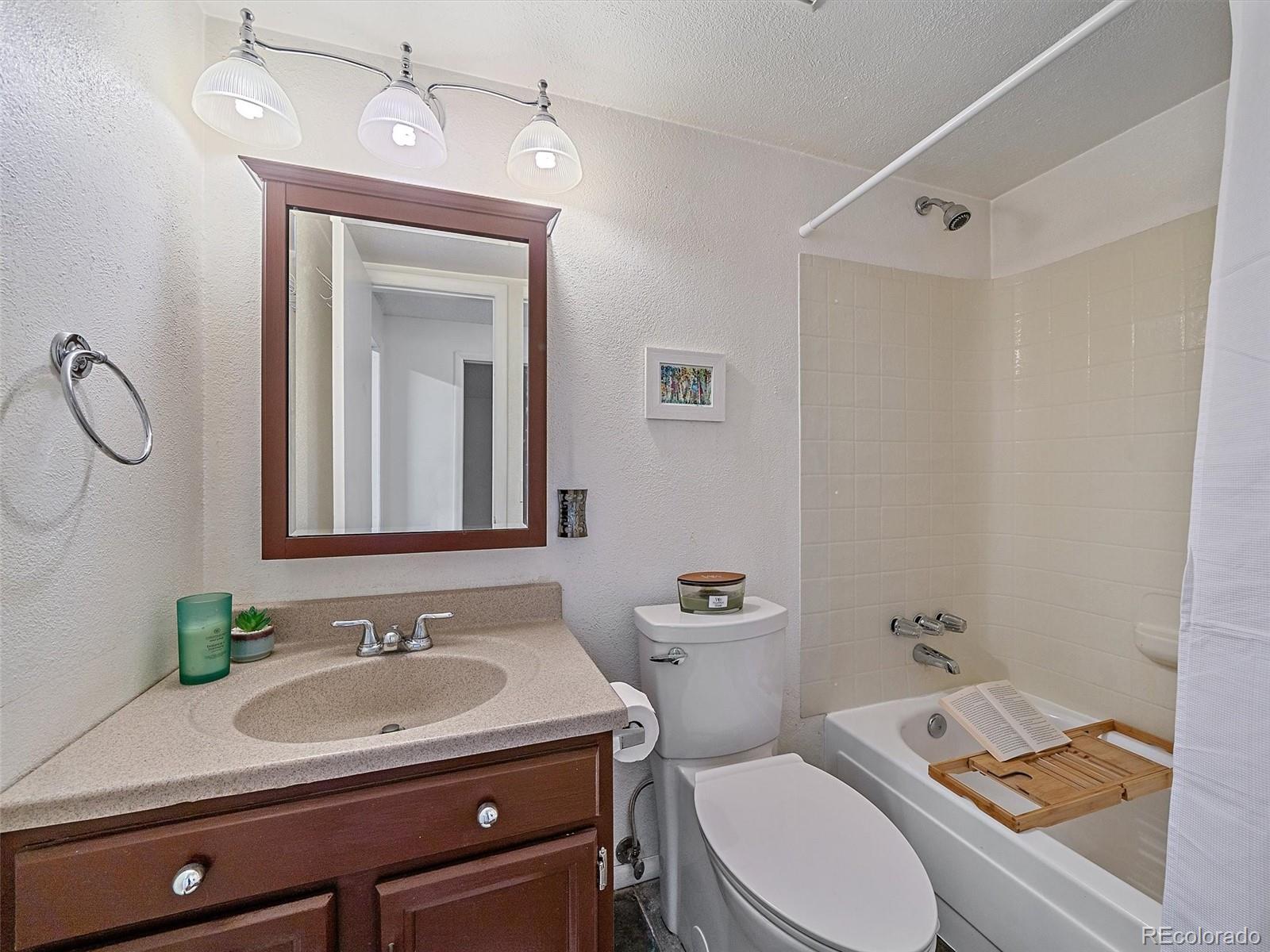 27422 Pine Valley Drive Evergreen, CO 80439 - Photo 28 of 42 a bathroom with a granite countertop sink toilet a mirror and shower