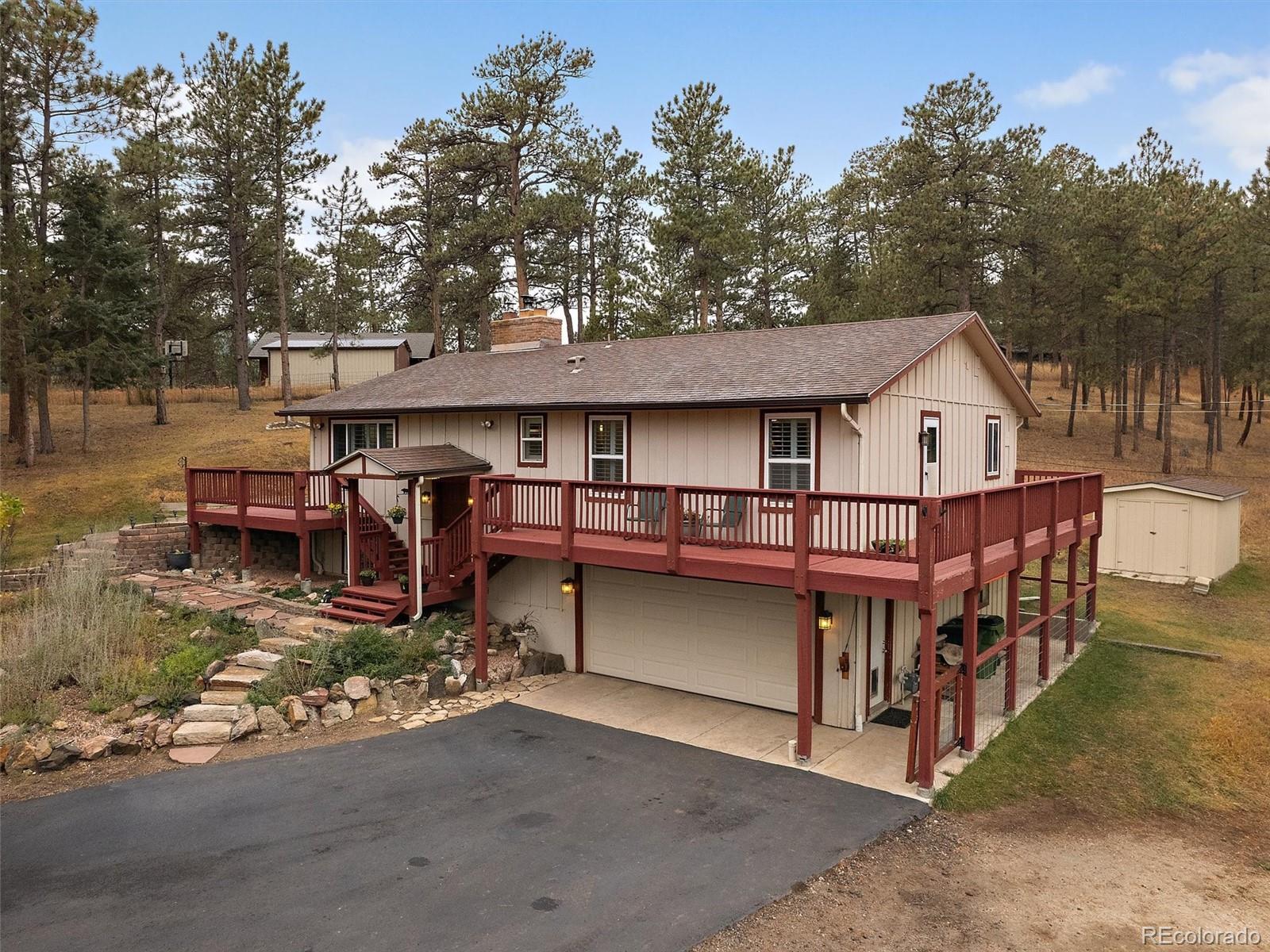 27422 Pine Valley Drive Evergreen, CO 80439 - Photo 3 of 42 a view of house with outdoor seating area and trees around