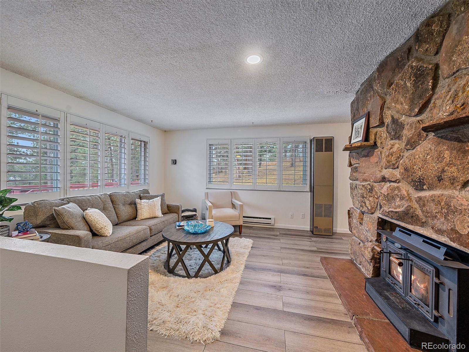 27422 Pine Valley Drive Evergreen, CO 80439 - Photo 4 of 42 a living room with furniture and a fireplace