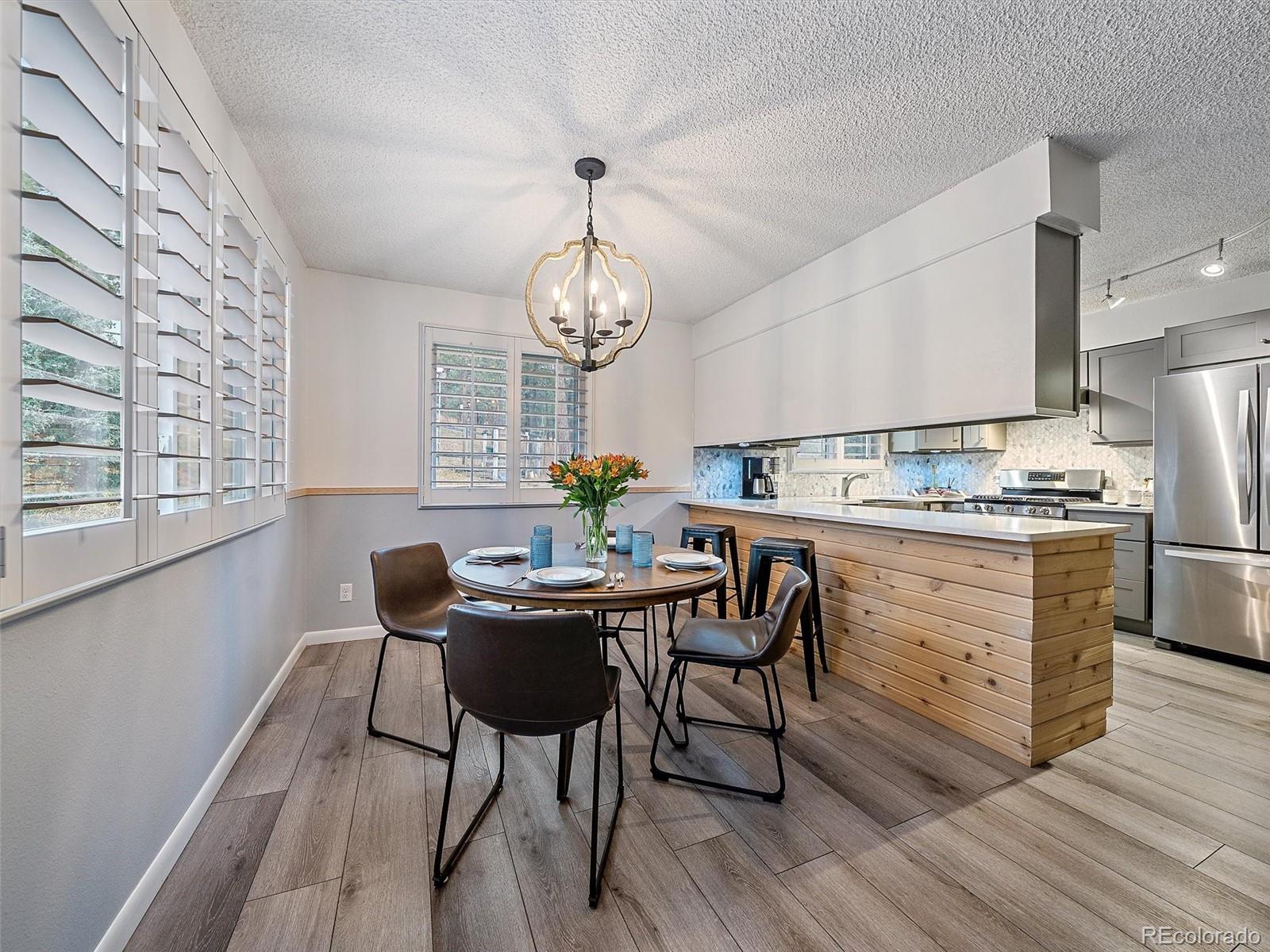 27422 Pine Valley Drive Evergreen, CO 80439 - Photo 6 of 42 a kitchen with a dining table chairs and refrigerator
